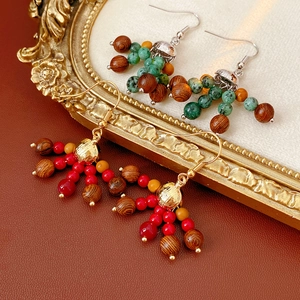 Detail of bohemian wood bead earrings on a vintage gold frame with natural stone accents