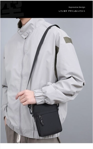 Detailed view of black nylon crossbody bag on model with adjustable strap and front pocket