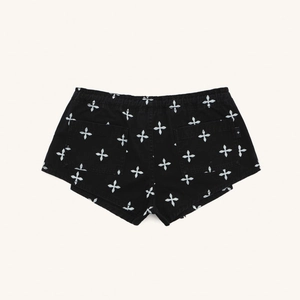 Detail view of black cargo shorts featuring white floral print and rear patch pockets