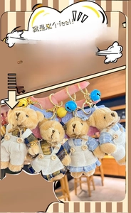 Detailed view of four plush teddy bear keychains with colorful clothes and metal bells