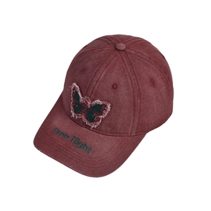 Detail of burgundy washed denim baseball cap with butterfly patch and embroidery