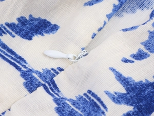 Vue macro détaillée de la fermeture éclair invisible sur le tissu imprimé bleu et blanc