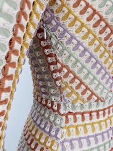 Dettaglio dell'abito in pizzo colorato all'uncinetto con motivi e cerniera laterale