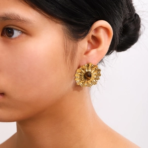 Elegant gold plated flower earrings with tiger eye stone on model earlobe