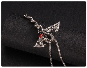 Détail du pendentif dragon argenté avec pierre rouge et design d'ailes complexe