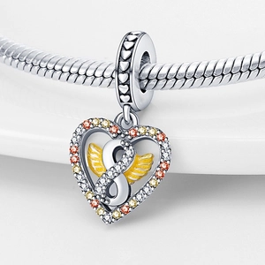 Macro shot of silver heart charm with infinity symbol, gold wings and zircon accents