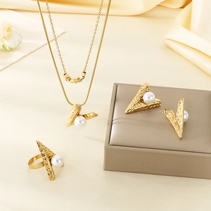 Artistic layout of gold-textured jewelry set with pearls and V-shaped elements
