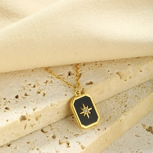 Macro shot of gold-plated necklace featuring a black rectangular starburst pendant