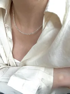 Detail of a dainty S925 sterling silver crushed silver necklace on a model's collarbone