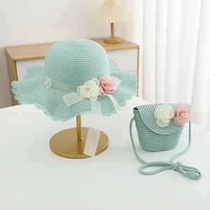 Close-up of mint green straw hat and matching bag with decorative floral accents