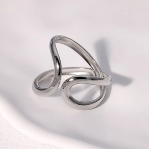 Close-up of a silver asymmetric geometric ring with wavy minimalist metal lines