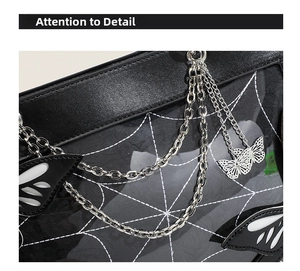 Close-up of gothic butterfly ita bag with spider web pattern and metal chains