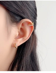 Detailed view of elegant gold double-layered ear cuff and stud set with white zircons