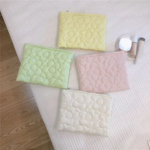 Quilted floral puffer cosmetic bags in pastel yellow, green, pink and white colors