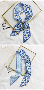 Close-up of a double-sided floral silk hair scarf with blue floral patterns and fine edges