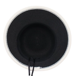 Detailed top view of a woven straw sun hat with a black crown and wide white contrast brim