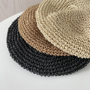 Close-up of handmade crochet berets showing intricate woven textures in three colors