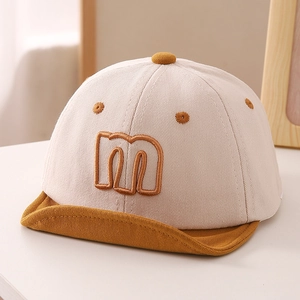 Detail of baby cotton cap with 3D letter embroidery and adjustable soft yellow brim
