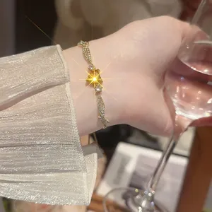 Elegant gold bracelet with sparkling heart zircon worn by a model holding a wine glass