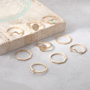 Detail view of 9-piece gold ring set featuring waves, geometric shapes and turquoise eye