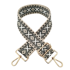 Detail of adjustable 5cm geometric jacquard bag strap with golden metal buckles