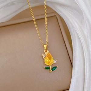 Close-up of golden tulip necklace pendant with yellow crystals and sparkling green stones