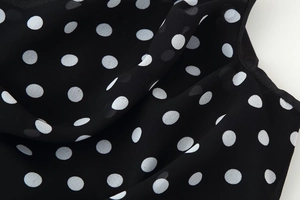 Macro shot of lightweight black chiffon fabric with white polka dots for woman dress
