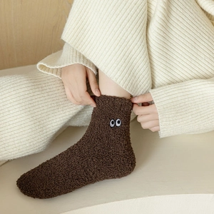 Detail of dark brown coral fleece socks with eye embroidery and soft thick texture