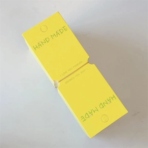 Detail view of yellow handmade paper cards with hanging holes for hair accessories packaging