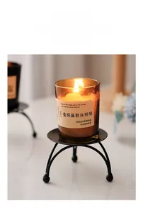 Minimalist black three-legged metal candle holder with elegant spherical feet detail
