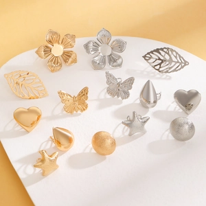 Flat lay of gold and silver boho rings with flower, leaf, and butterfly motifs