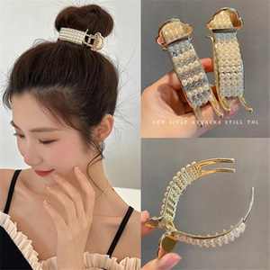 Detail of elegant gold claw clip with multi-row pearls and rhinestones for hair styles