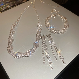 Detailed flat lay of silver rhinestone jewelry set with twisted necklace and earrings