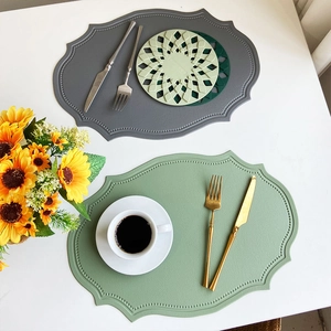 Detail view of grey and green faux leather placemats with retro embossed dot textures