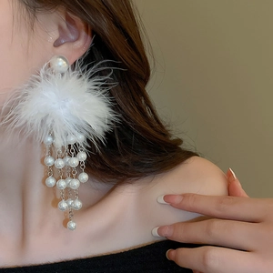 Detailed view of elegant long tassel earrings with white feathers and faux pearls for women