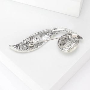 Vintage silver leaf brooch featuring intricate floral engraving and secure pin closure
