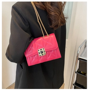 Detail of fuchsia quilted crossbody bag with heart embroidery and gold jewel clasp