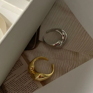 Polished minimalist gold and silver irregular heart rings on a vintage paper background