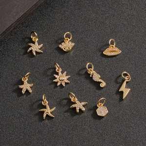 Gouden DIY metalen bedeltjes set met zeester, zon en lippen op zwarte achtergrond