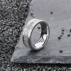 Detailed macro view of men's stainless steel ring with vertical textures and zircon inlay