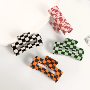 Chic checkered claw clip set in black, pink, green, and orange on a white tray