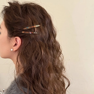Retro amber hair clips set in French style worn on brown wavy hair for a chic look