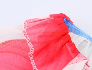 Détail du haut en mousseline fleurie montrant le tissu rouge blanc et l'ourlet bleu