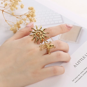Detail of gold sun and octopus shaped adjustable rings worn on hand in a stylish setting