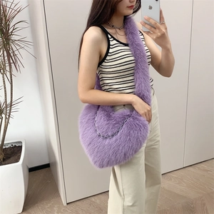 Close-up of purple plush heart-shaped crossbody bag with decorative silver metal chain