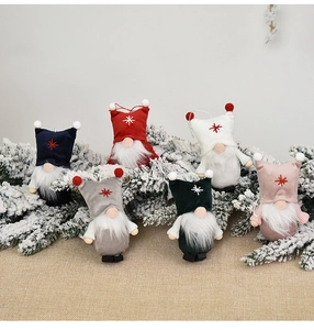 Close-up of colorful Christmas gnomes hanging on pine branches with stars