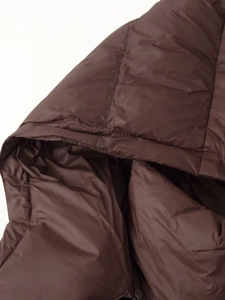 Détail du tissu matelassé marron foncé de la doudoune avec des coutures de qualité