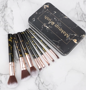 Detailed view of marble-patterned makeup brushes and a black metal storage case
