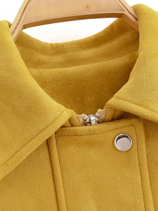 Detailed macro view of yellow suede jacket collar with silver metal buttons and stitching