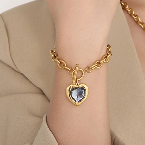 Detail of gold chunky chain bracelet with heart crystal pendant and OT toggle clasp